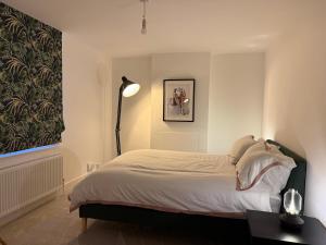 a bedroom with a bed and a lamp in it at 5 Bed Cottage in Enfield