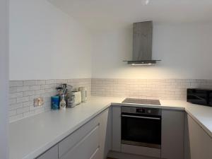a kitchen with white counters and a stove top oven at 5 Bed Cottage in Enfield