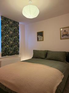 a bedroom with a bed and a large window at 5 Bed Cottage in Enfield