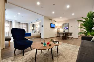 a living room with a bed and a couch and a table at Hotel Salobreña Suites in Salobreña