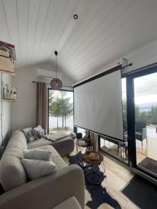 a living room with a couch and a large screen at Na samote u Noemi in Komjatná
