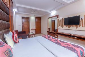 a hotel room with a bed and a tv at Avtar new delhi railway station in New Delhi