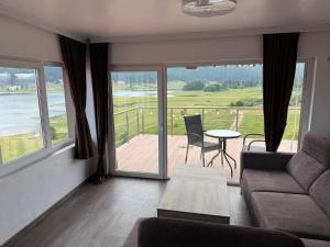 a living room with a couch and a table and a balcony at Complex Forest Sarnitsa in Sarnitsa