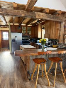 a kitchen with a large wooden island with two bar stools at Yellowstone House in Livingston