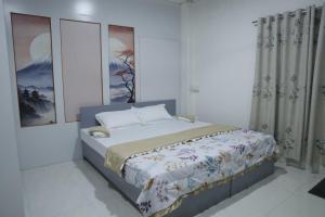 a bedroom with a bed in a white room at Zosang Homestay in Āīzawl