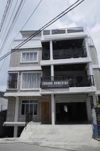 a white building with a sign that reads jamaican embassy at Zosang Homestay in Āīzawl