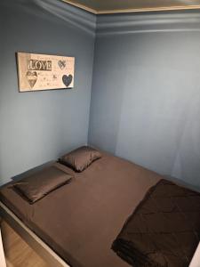 a bed in a room with a sign that reads love at L'Orée du bois in Membre