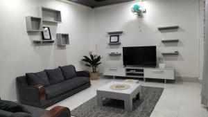 a living room with a couch and a flat screen tv at Zosang Homestay in Āīzawl