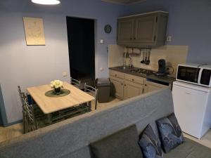 a kitchen with a small table and a kitchen with a microwave at L'Orée du bois in Membre +13 photos