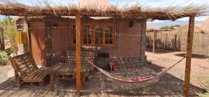 a small hut with a hammock outside of it at Domo del desierto in San Pedro de Atacama