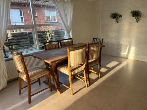 a wooden dining room table with chairs and a window at Stort byhus i Lemvig in Lemvig