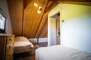 a bedroom with a bed and a wooden ceiling at Domek Umilenia in Mrzygłód