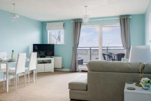 a living room with a couch and a table at Ocean Breeze - Stunning Harbour Views from Private Balcony in Poole +18 photos