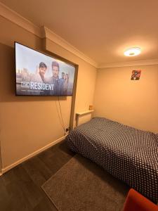 a bedroom with a bed and a television on the wall at Demure Living Space in Southampton