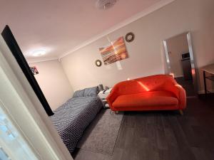 a bedroom with a bed and a red chair at Demure Living Space in Southampton