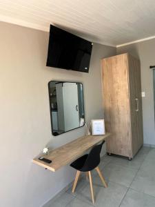 a desk in a room with a mirror and a chair at Stay at Tzaneen in Tzaneen