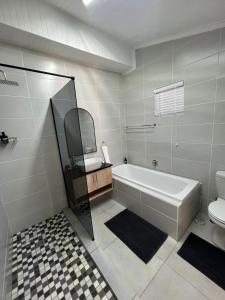 a bathroom with a bath tub and a toilet at Stay at Tzaneen in Tzaneen