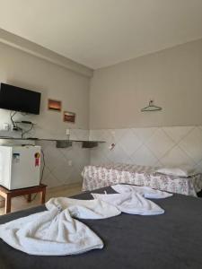 a bedroom with two white towels on a bed at Beiral Pousada E Restaurante in Ponta do Mel