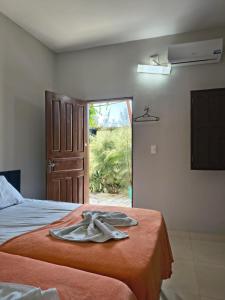a robe is sitting on a bed in a room at Beiral Pousada E Restaurante in Ponta do Mel