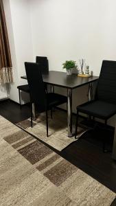 a dining room table with two chairs and a plant on it at SCC2 Apartments in Cluj-Napoca