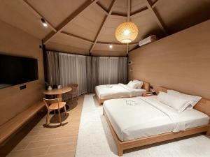 a hotel room with two beds and a television at Pudina Resort in Semporna