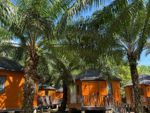 a row of houses with palm trees in front of them at Pudina Resort in Semporna