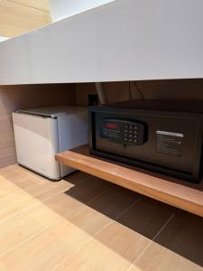 a microwave sitting on a shelf next to a refrigerator at Pudina Resort in Semporna