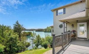 a house with a deck with a view of a lake at Lighthouse Lookout by Beyond Expectations - Hot Tub & Lake Views in Sevierville