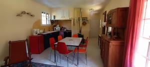 a kitchen with a table and red chairs in it at Le Village Champignon in Aspet +8 photos