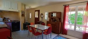a kitchen with a table and red chairs in it at Le Village Champignon in Aspet