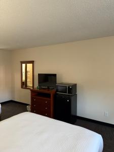 a bedroom with a bed and a microwave and a television at Great Smokies Inn - Cherokee in Cherokee