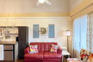 a living room with a red couch and a kitchen at Haven at Hazel~Downtown Bungalow in Demorest +12 photos