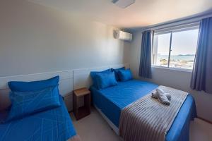 a bedroom with two beds and a window at Curta Praia do Quilombo - Lunata in Penha +290 photos