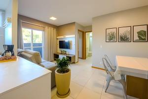 a kitchen and living room with a couch and a table at Curta Praia do Quilombo - Lunata in Penha