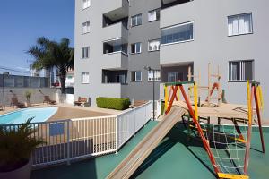 an apartment with a playground in front of a building at Curta Praia do Quilombo - Lunata in Penha