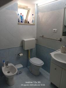 a bathroom with a toilet and a sink at Vico Girone in Patti +9 photos