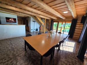a dining room with a wooden table and chairs at Vila Noruciai in Šašeliai