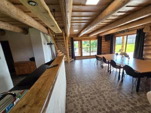 a dining room with a table and chairs and wooden ceilings at Vila Noruciai in Šašeliai