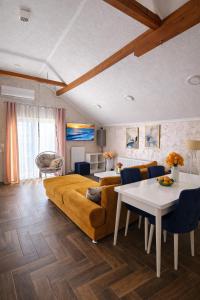 a living room with a couch and a table at Sunrise Riverside House-Private Garden, Jacuzzi & BBQ in Čelarevo