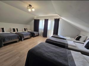 a room with four beds and a window at Vila Noruciai in Šašeliai