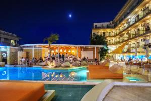 a pool at a hotel with people sitting around it at Asana Hotel in Hersonissos