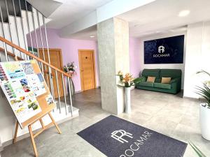 a lobby with a green couch and a staircase at Pensión Rocamar in Almuñécar