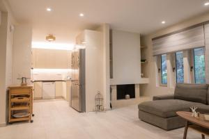 a living room with a couch and a kitchen at THALIA, luxury 3Br Home with Ensuite Bathrooms, just 3 minutes walk from the beach located in the prestigious Athenian Riviera in Athens +31 photos