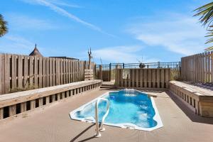 a swimming pool in a backyard with a wooden fence at Beachfront home with pool elevator dog-friendly in St. George Island