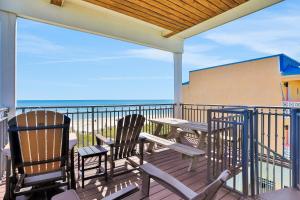 two chairs and a table on a balcony with the ocean at Beachfront home with pool elevator dog-friendly in St. George Island