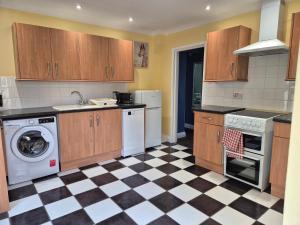 a kitchen with wooden cabinets and a checkered floor at Tommy Two-Threes in Pill