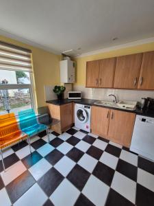 a kitchen with a black and white checkered floor at Tommy Two-Threes in Pill +13 photos