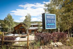 a sign for a boulder creek lodge in front of a building at The Boulder Creek Lodge in Nederland