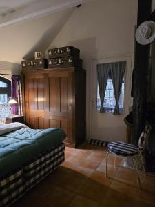 a bedroom with a bed and a chair in it at Op Vakantie bij Nicole in Putten