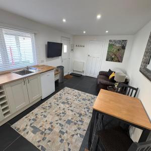 a kitchen and living room with a sink and a couch at Santa's Cottage in Torquay +5 photos